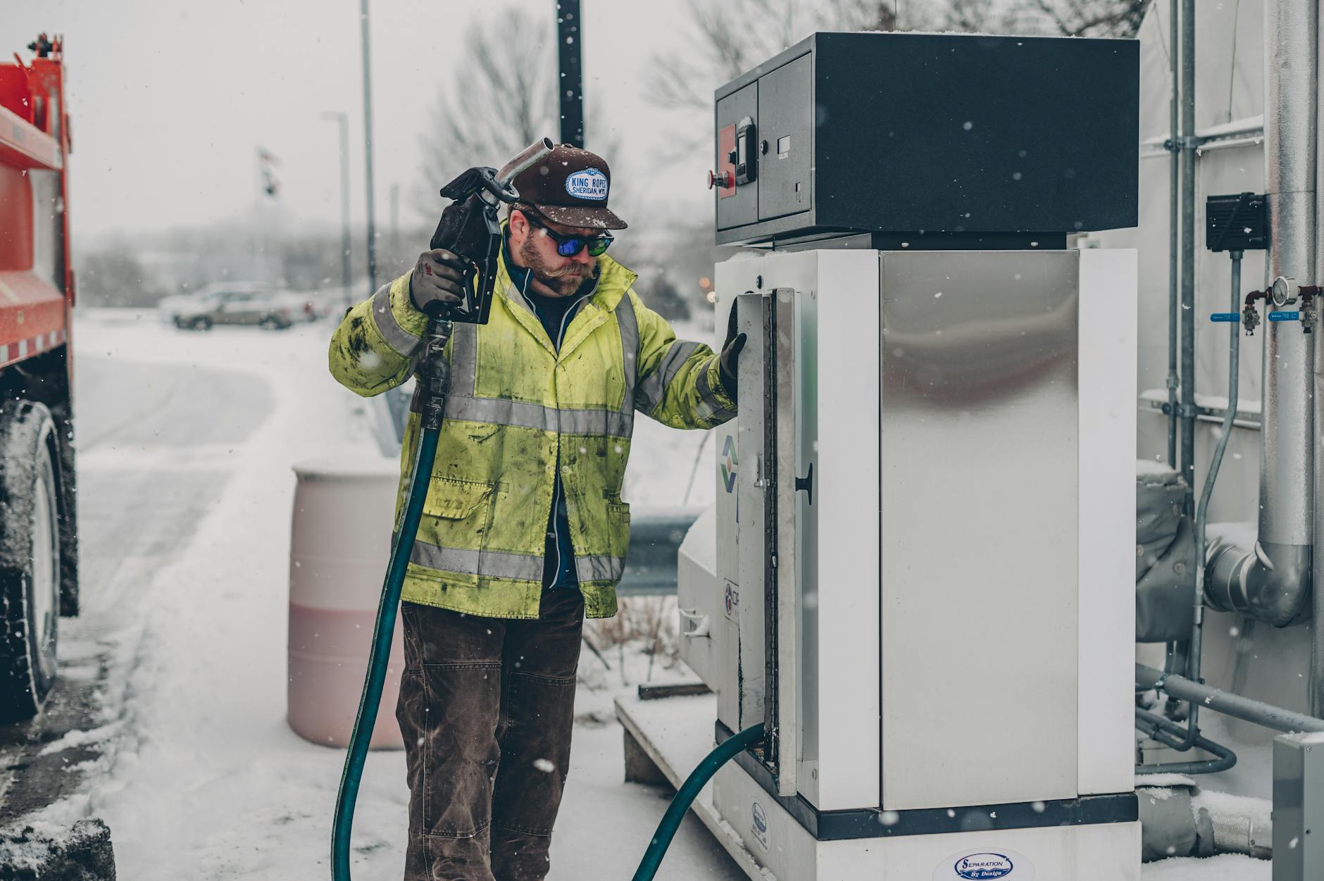 Jak bezpiecznie tankować samochód ciężarowy na CNG i LNG: praktyczny poradnik dla kierowców i firm transportowych Kierowca tankuje ciężarówkę na zimowej stacji paliw