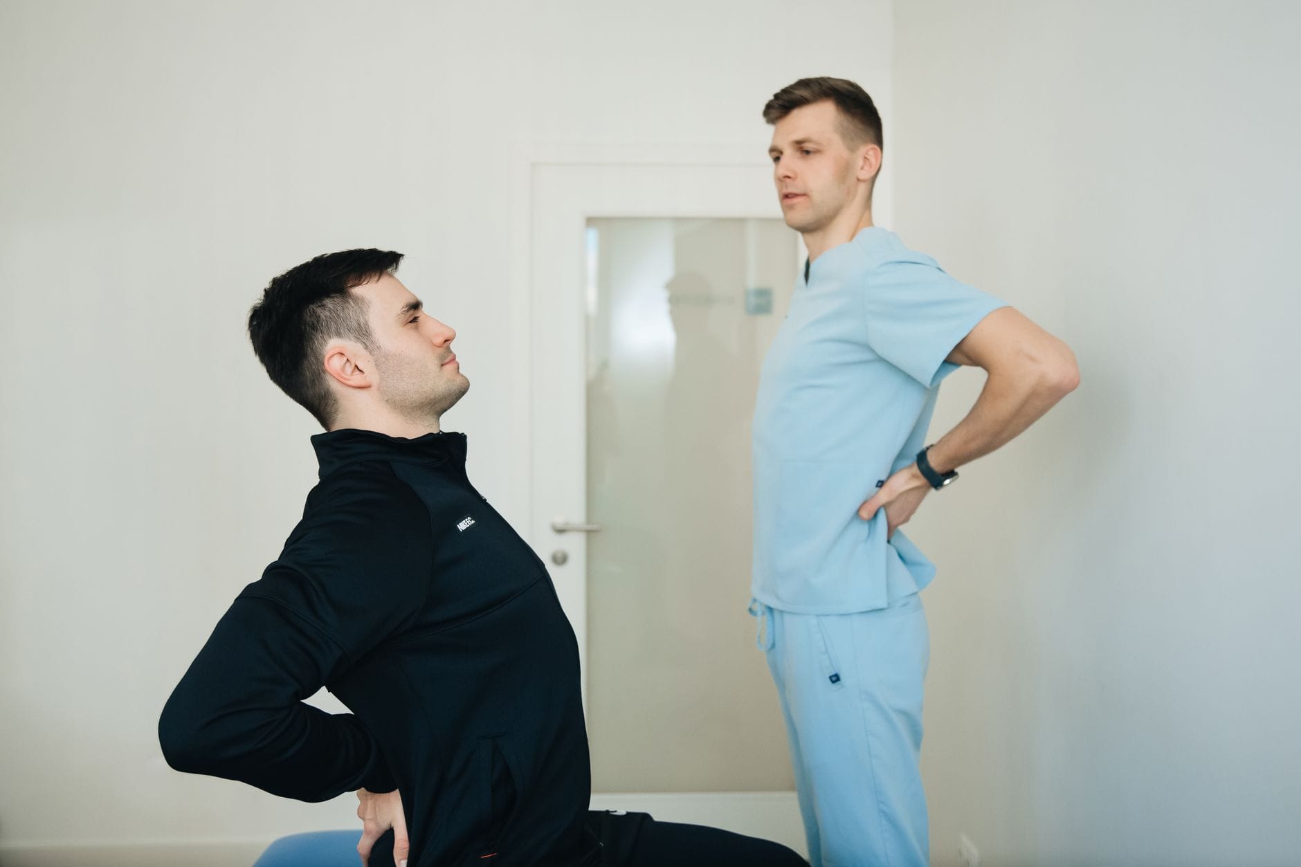 Fizjoterapeuta pokazuje pacjentowi ćwiczenia mobilizujące kręgosłup
