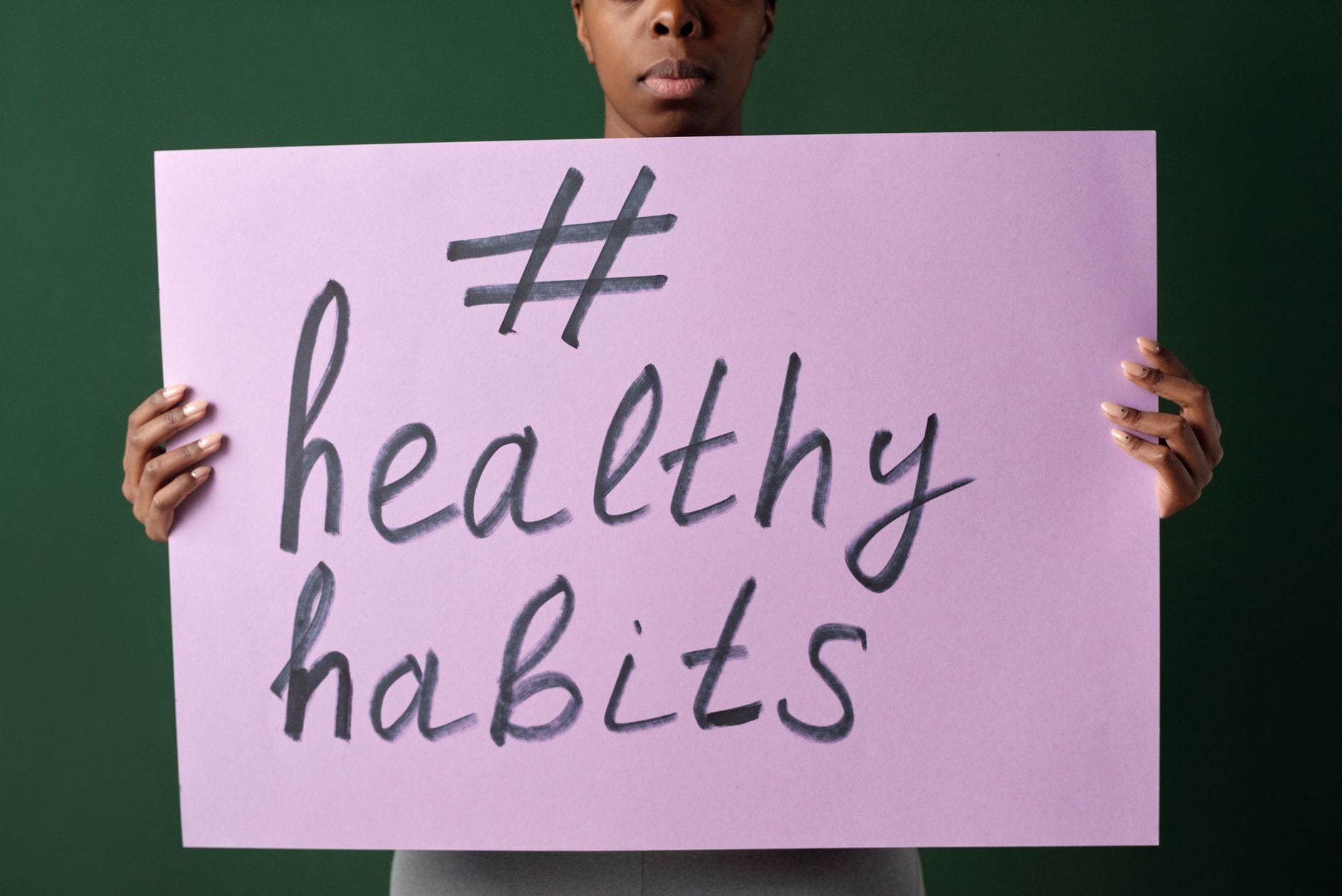 Osoba trzyma kartkę z napisem #healthyhabits promującą zdrowe nawyki
